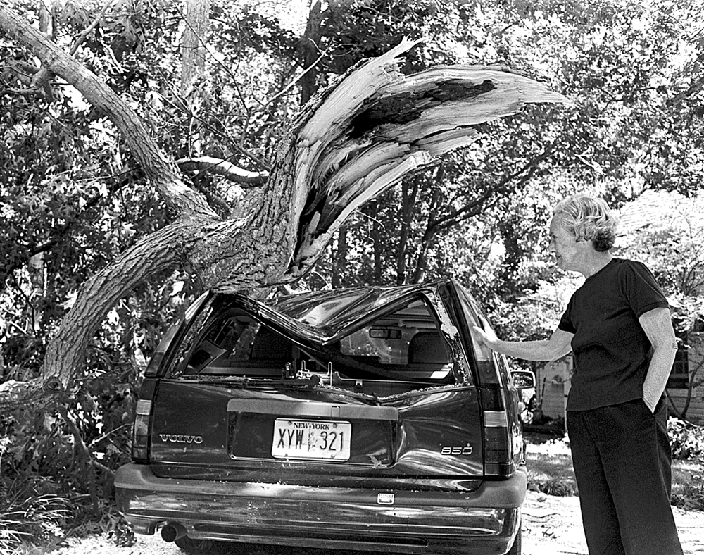 Marcia Brown beside an oak that fell atop her volvo on Nassau Point. (Judy Ahrens photo, file)