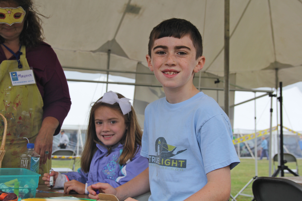 Eight-year-old Noah Benson and his sister Connie, 5, at the children's ministry tent led by members of the True Light Church of Cutchogue.   