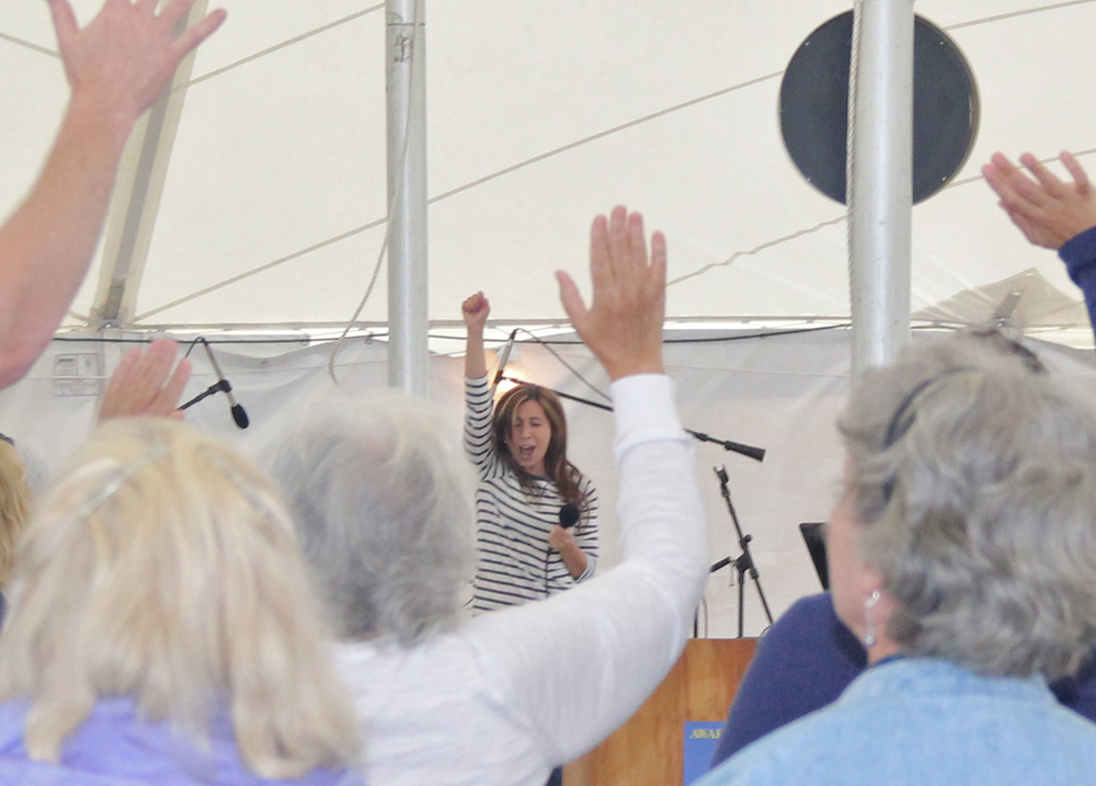 Gina Dellosso of Crossing Jordan Worship Band leads the crowd to their feet.  