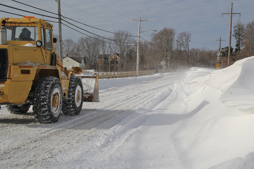 A lone dozer makes its way down Main Road in Orient, driving through one of many snow drift areas. (Credit: Carrie Miller)