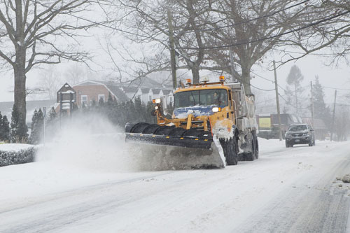 KATHARINE SCHROEDER PHOTO | A snow plow clears the road near Mattituck. 