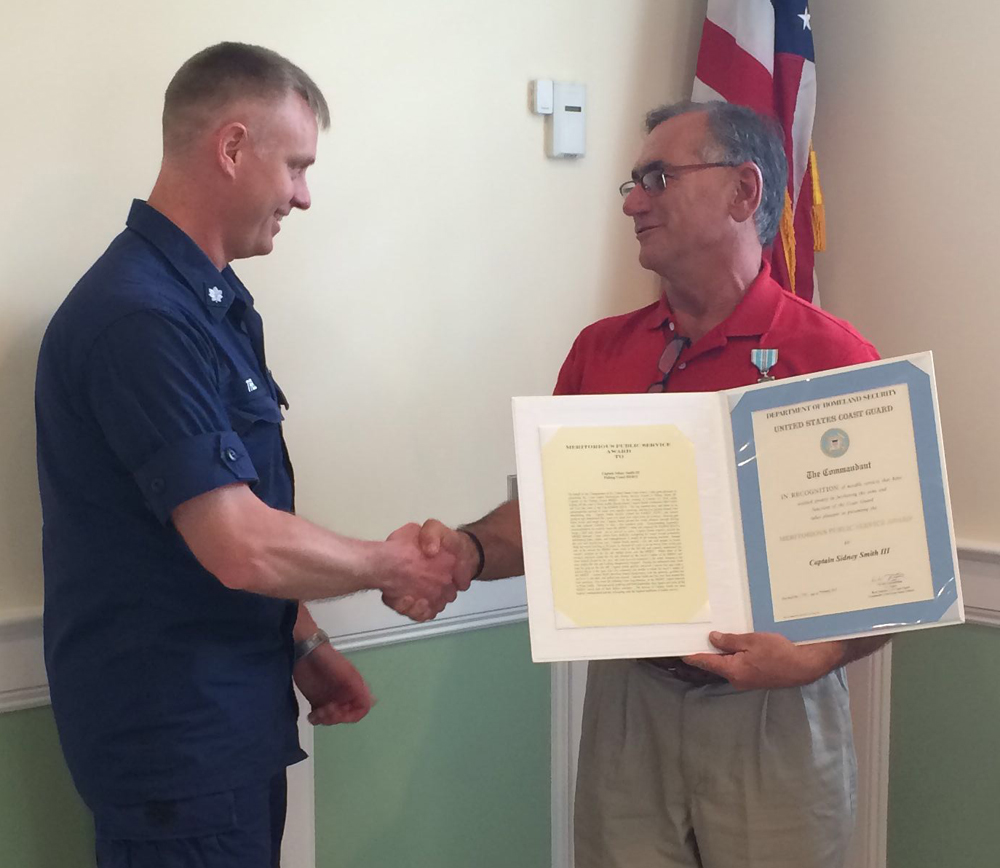 Cmdr. Jonathan Theel, of Sector Long Island Sound (left) presents the commendation to Greenport fishing captain Sid Smith. (Credit: courtesy)