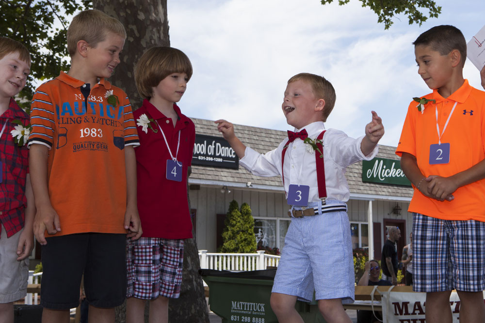 Ryan Harned, 6, of Cutchogue, reacts when he hears his name called as winner of the Little Mr. Mattituck contest. (Credit: Katharine Schroeder)