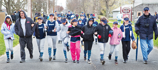 An Oysterponds team marches up Peconic Lane in Peconic with other North Fork Little League players and coaches in Saturday's opening day parade. The march proceeded to Tasker Park for games and entertainment.