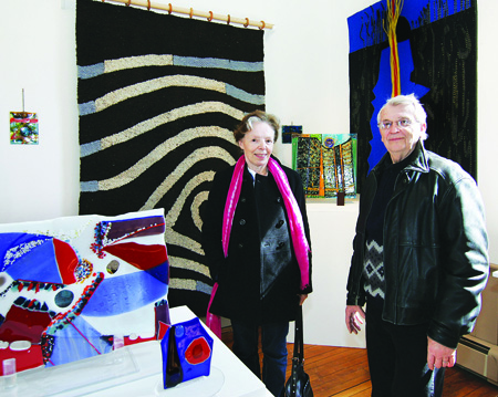 Artists Francoise and Yan Rieger pose with their work at Oysterponds Historical Society's 'Fiber & Glass' exhibit, which opened April 2 in the Old Point Schoolhouse in Orient. The show, which runs until April 23, features a collection of Ms. Rieger's colorful tapestries and Mr. Rieger's fused art glass.
